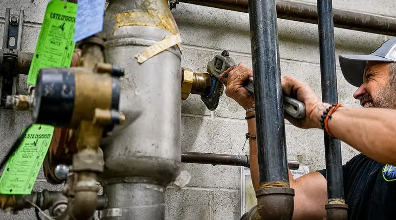 Element plumber adjusting a main water line valve in St. George, UT