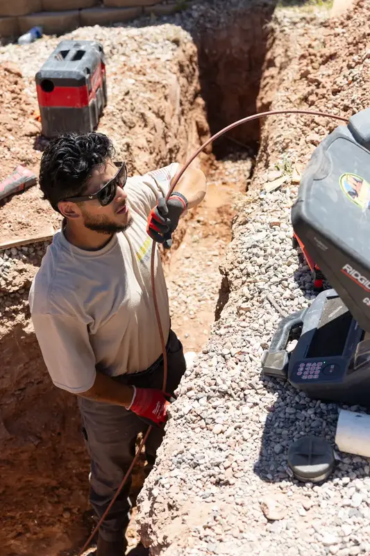 Element plumber running a sewer camera in a trench in St. George, UT