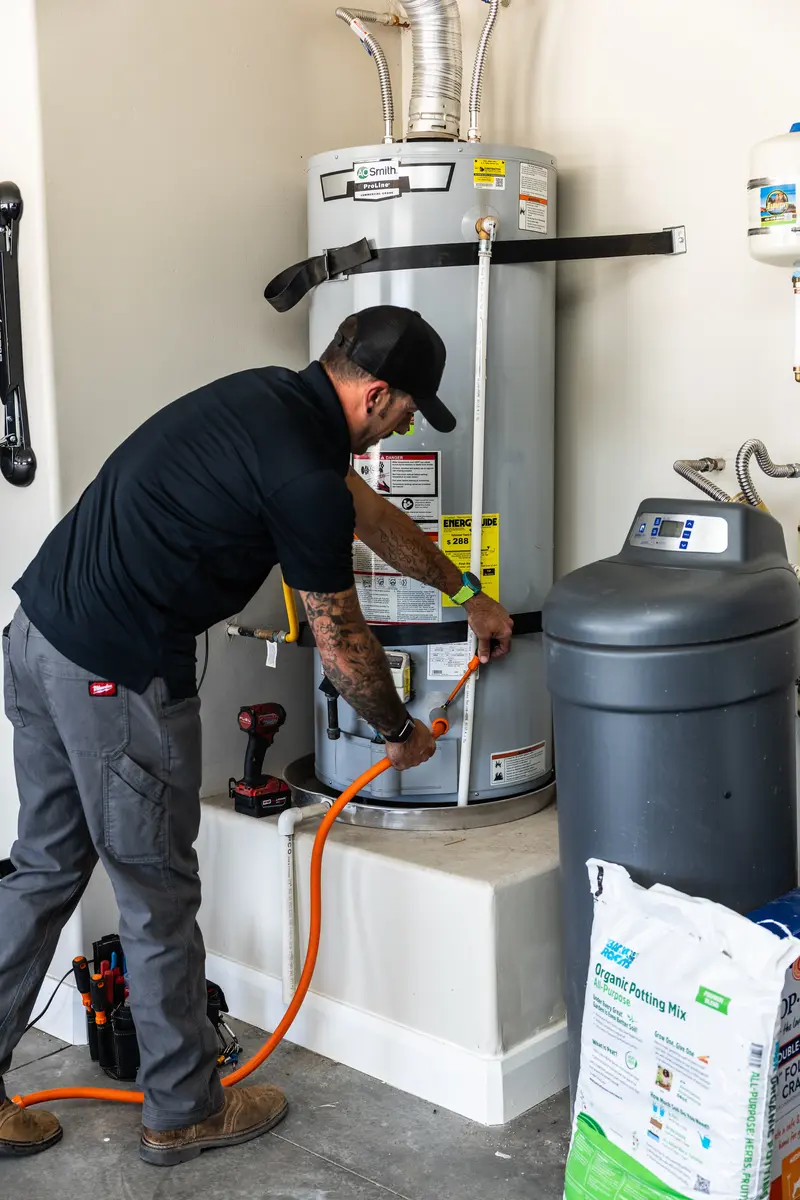 Element technician servicing a water heater in a garage in St. George, UT